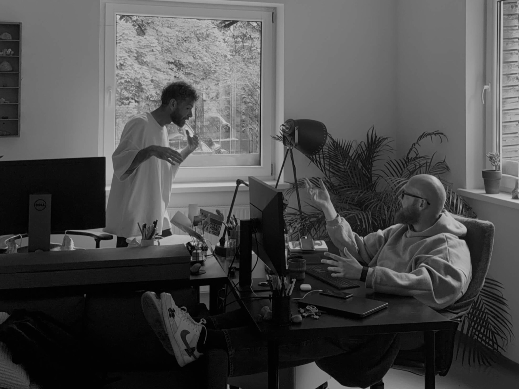 Vadzim and Vitali, co-founders of nity, mid-conversation at a shared desk in the Vilnius studio.